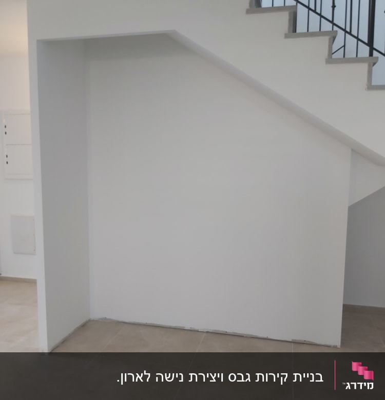 קיר גבס מתחת למדרגות עם רצפת אריחים